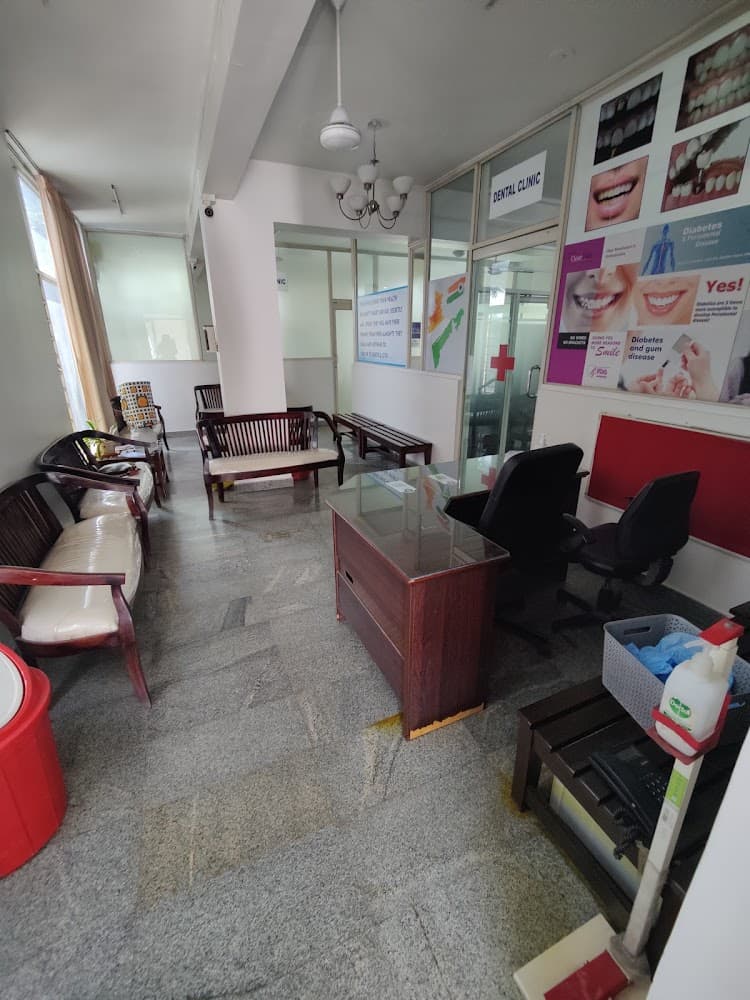 Waiting area at Dr Bhat Skin Clinic: wooden chairs and a glass-topped reception desk on a grey granite floor